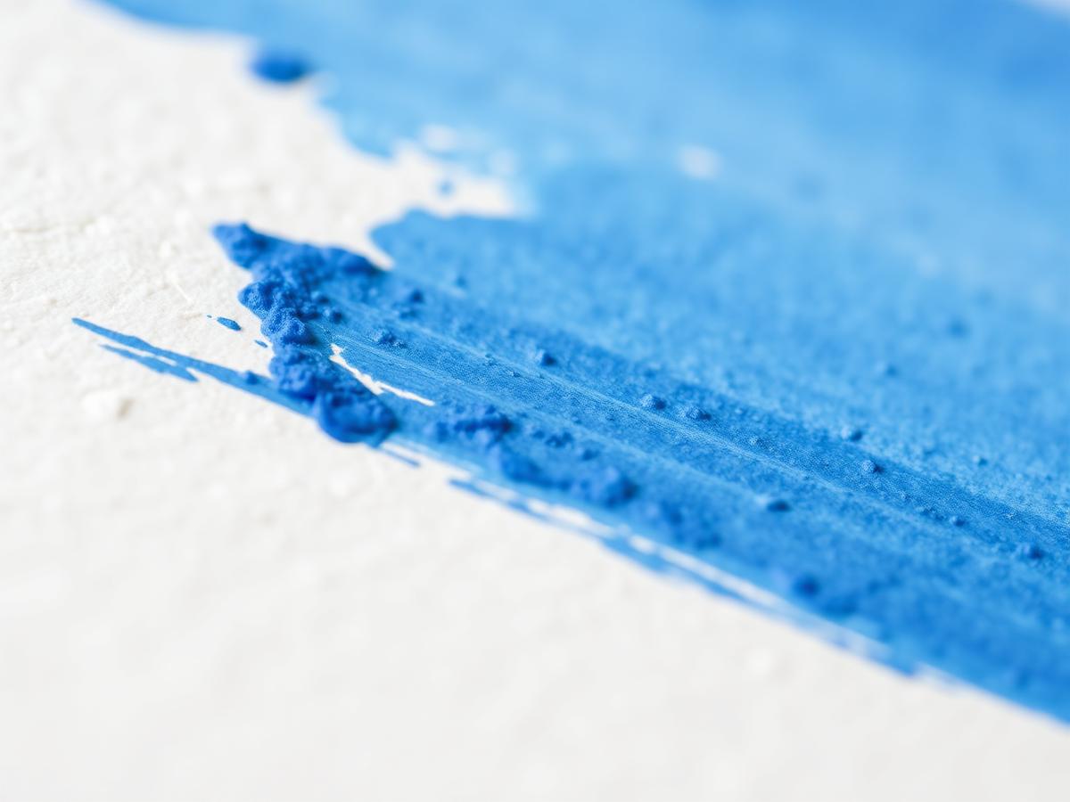 Close-up of blue brushstrokes on textured paper